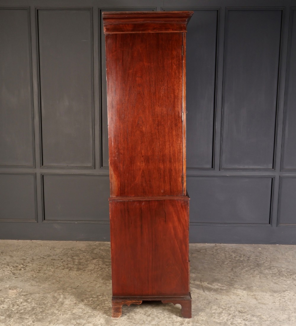 A Georgian mahogany linen press featuring botanical marquetry inlay on upper double doors over four lower drawers with brass handles. View X