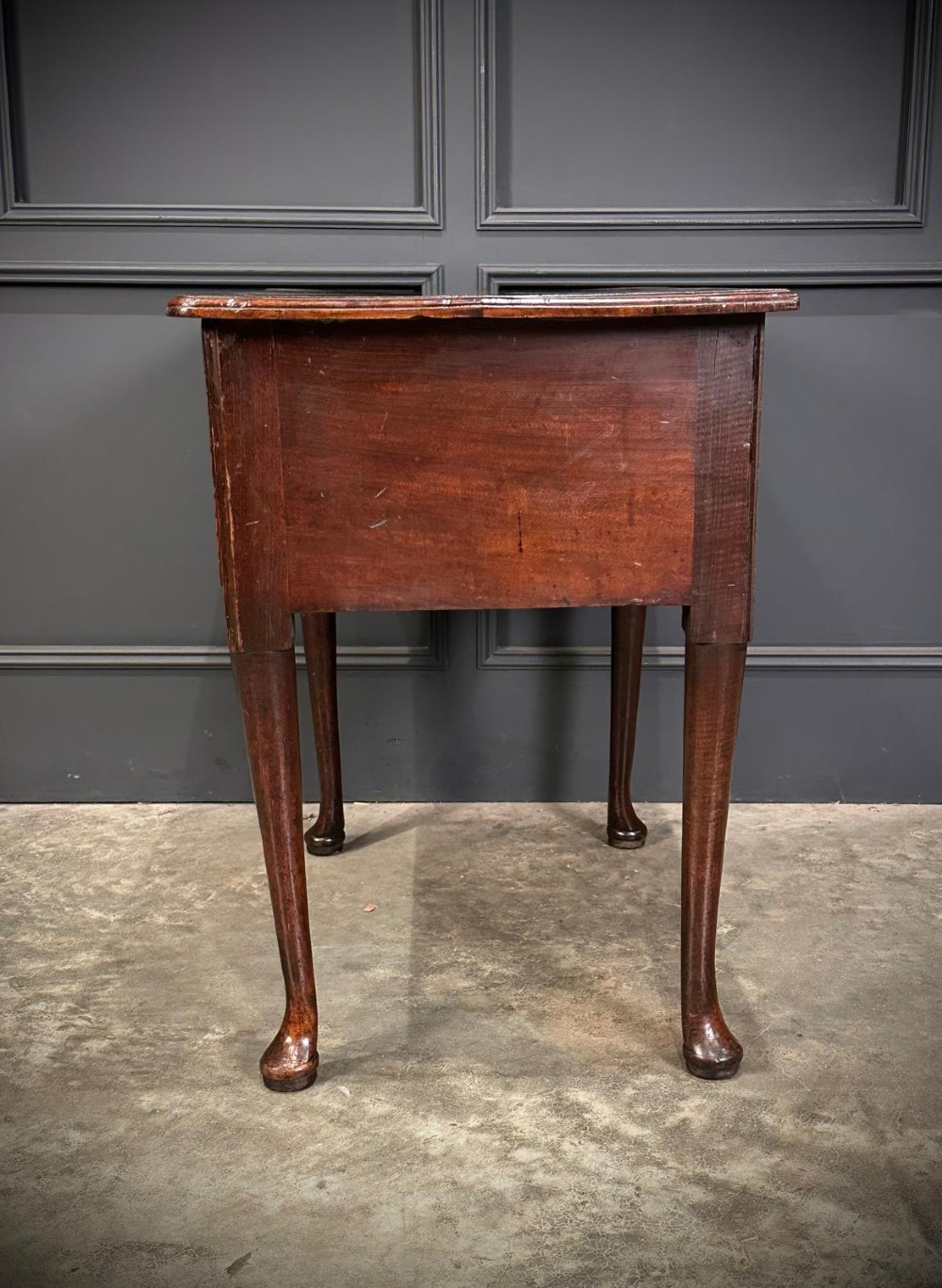 A Queen Anne dark oak lowboy featuring three drawers with brass backplate handles resting on slender cabriole legs with pad feet. View IX