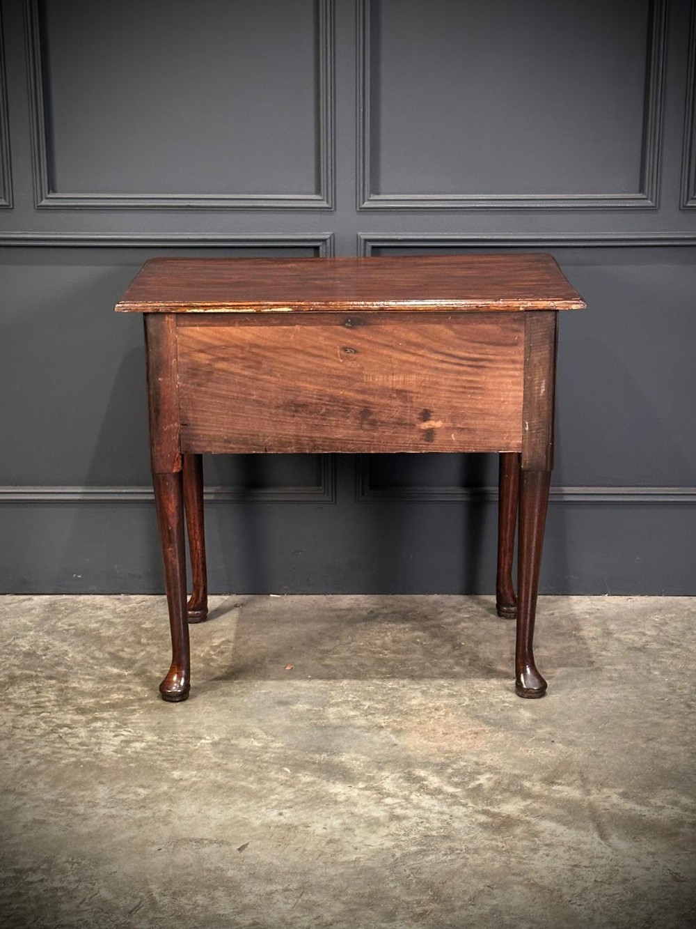A Queen Anne dark oak lowboy featuring three drawers with brass backplate handles resting on slender cabriole legs with pad feet. View X