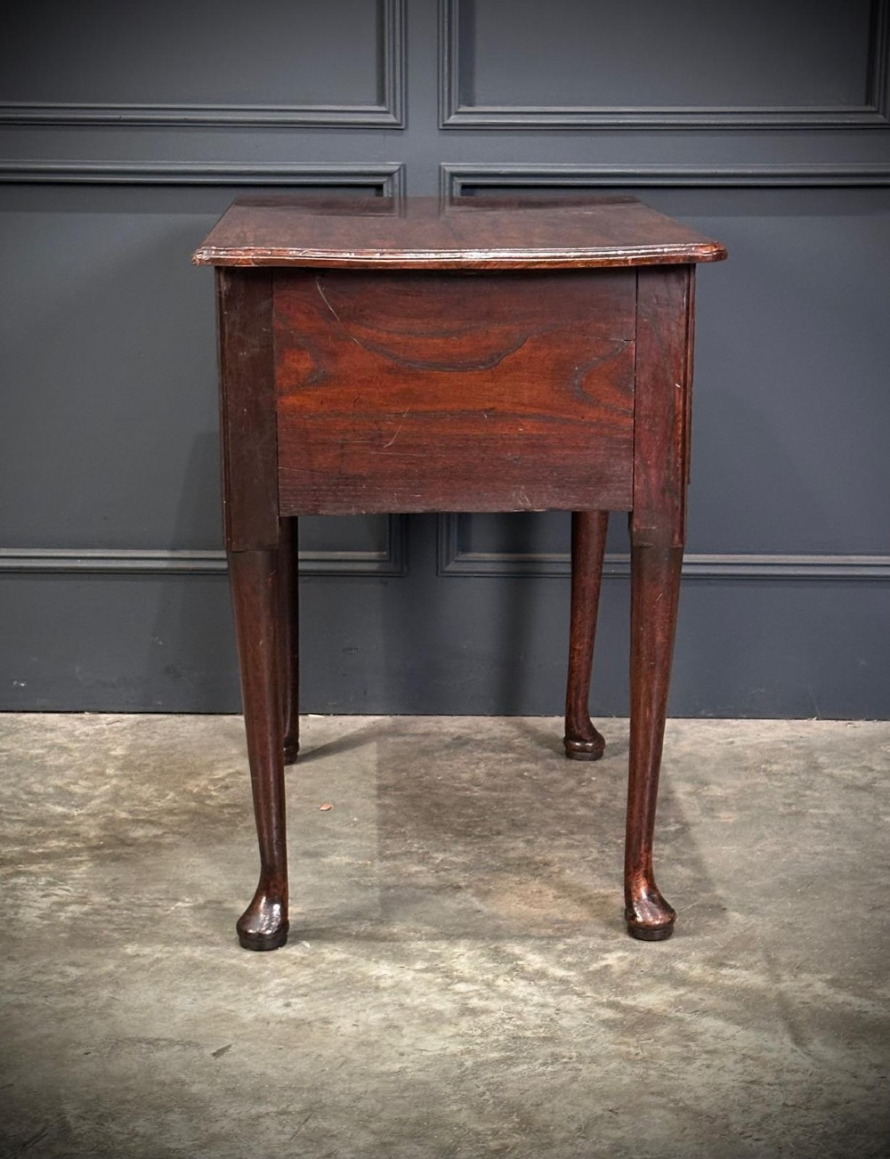 A Queen Anne dark oak lowboy featuring three drawers with brass backplate handles resting on slender cabriole legs with pad feet. View XII