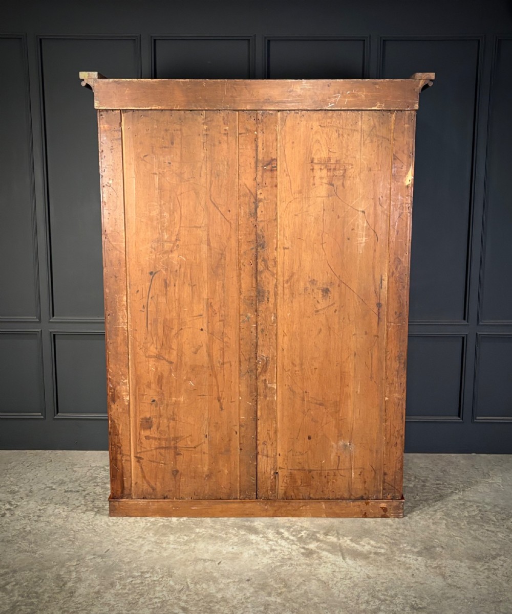 A Victorian double-door wardrobe crafted from figured burr walnut featuring arched door panels and a rounded moulded cornice. View IV