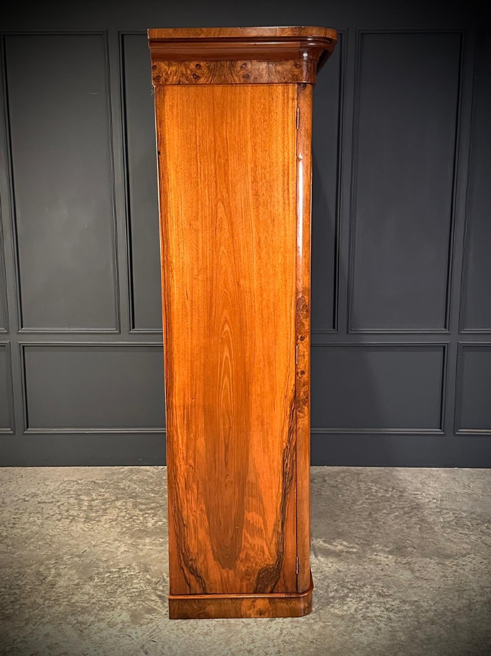 A Victorian double-door wardrobe crafted from figured burr walnut featuring arched door panels and a rounded moulded cornice. View VI