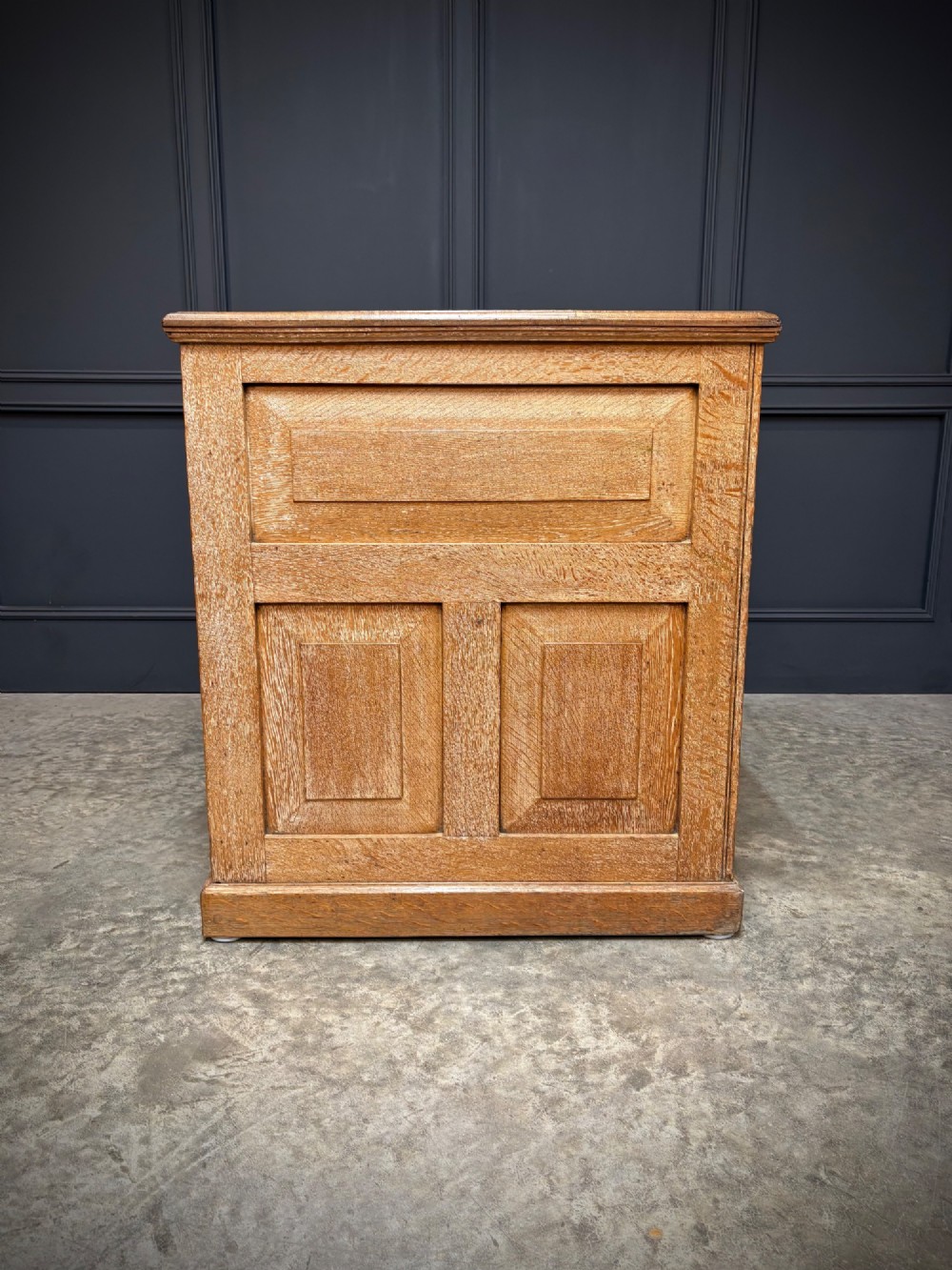 A 19th-century oak kneehole desk featuring nine drawers, brass drop handles, and a green leather inset writing top. View XI