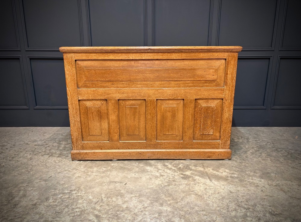 A 19th-century oak kneehole desk featuring nine drawers, brass drop handles, and a green leather inset writing top. View XII
