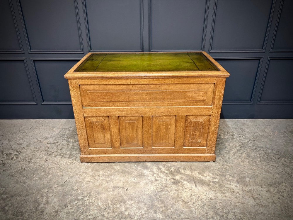 A 19th-century oak kneehole desk featuring nine drawers, brass drop handles, and a green leather inset writing top. View XIII