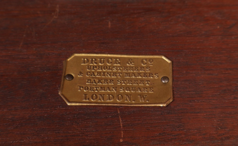 A large Sheraton style mahogany serving table featuring a rectangular top, frieze carved with drapery swags and a central urn relief, supported by four tapered fluted legs. View VIII
