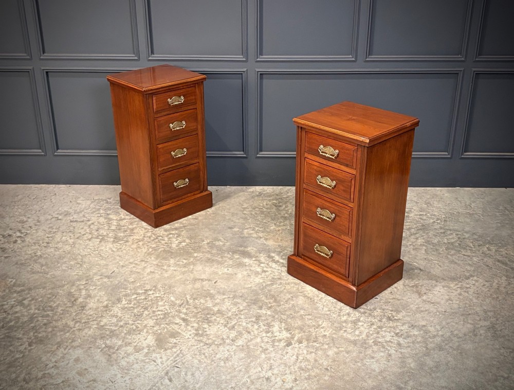 A pair of matching Victorian walnut bedside chests featuring four drawers each, brass drop handles, and a solid plinth base. View II