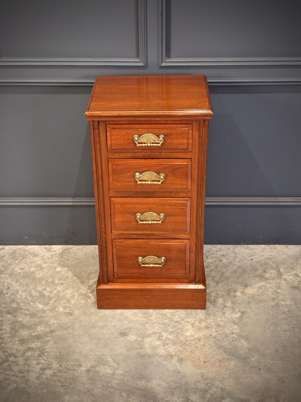 A pair of matching Victorian walnut bedside chests featuring four drawers each, brass drop handles, and a solid plinth base. View V