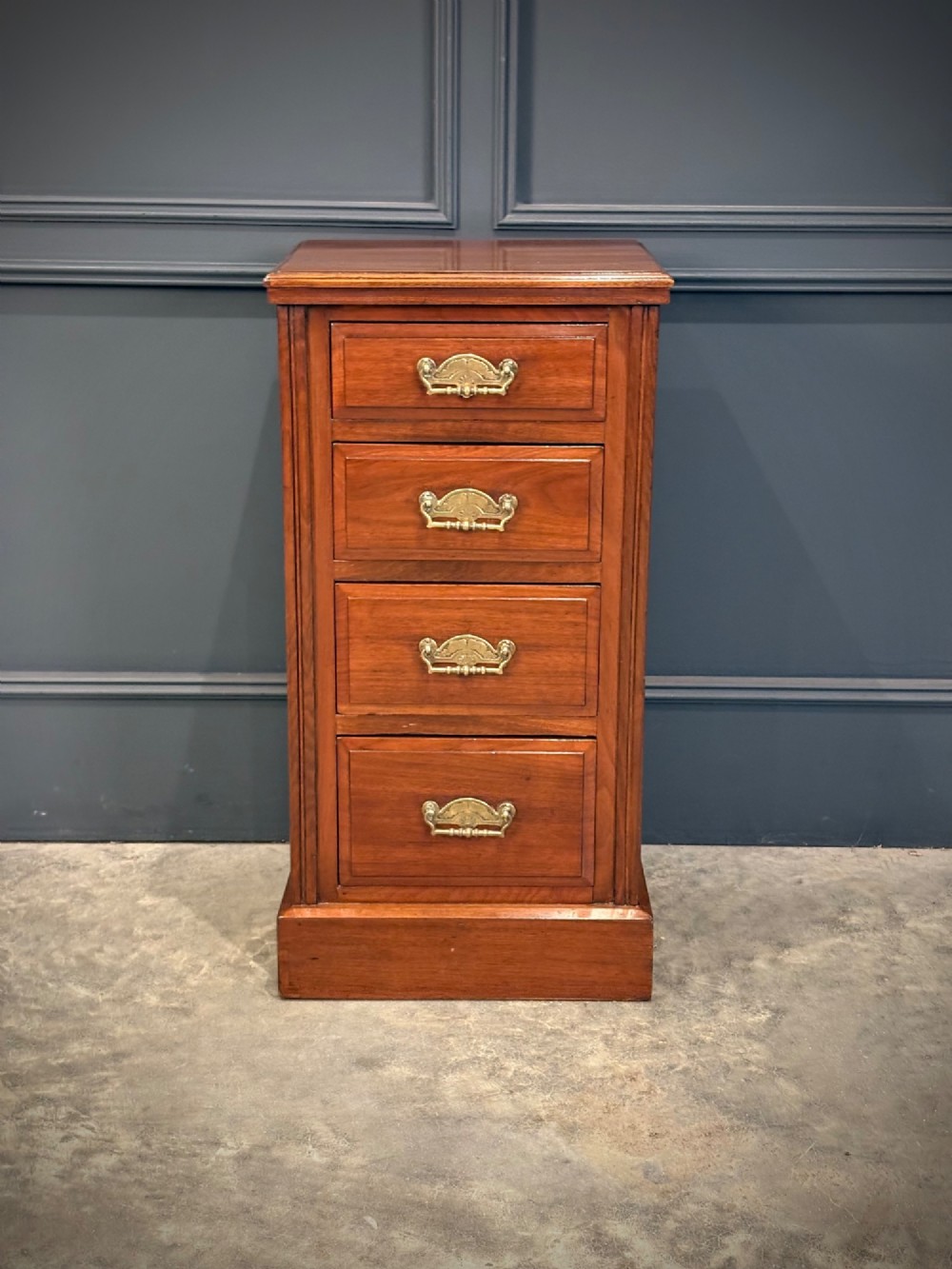 A pair of matching Victorian walnut bedside chests featuring four drawers each, brass drop handles, and a solid plinth base. View VI