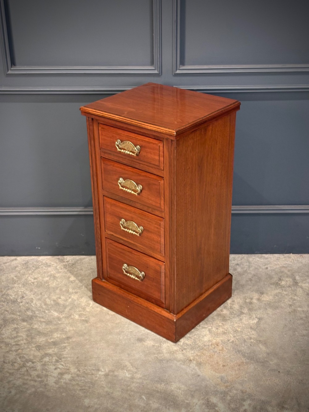 A pair of matching Victorian walnut bedside chests featuring four drawers each, brass drop handles, and a solid plinth base. View VII