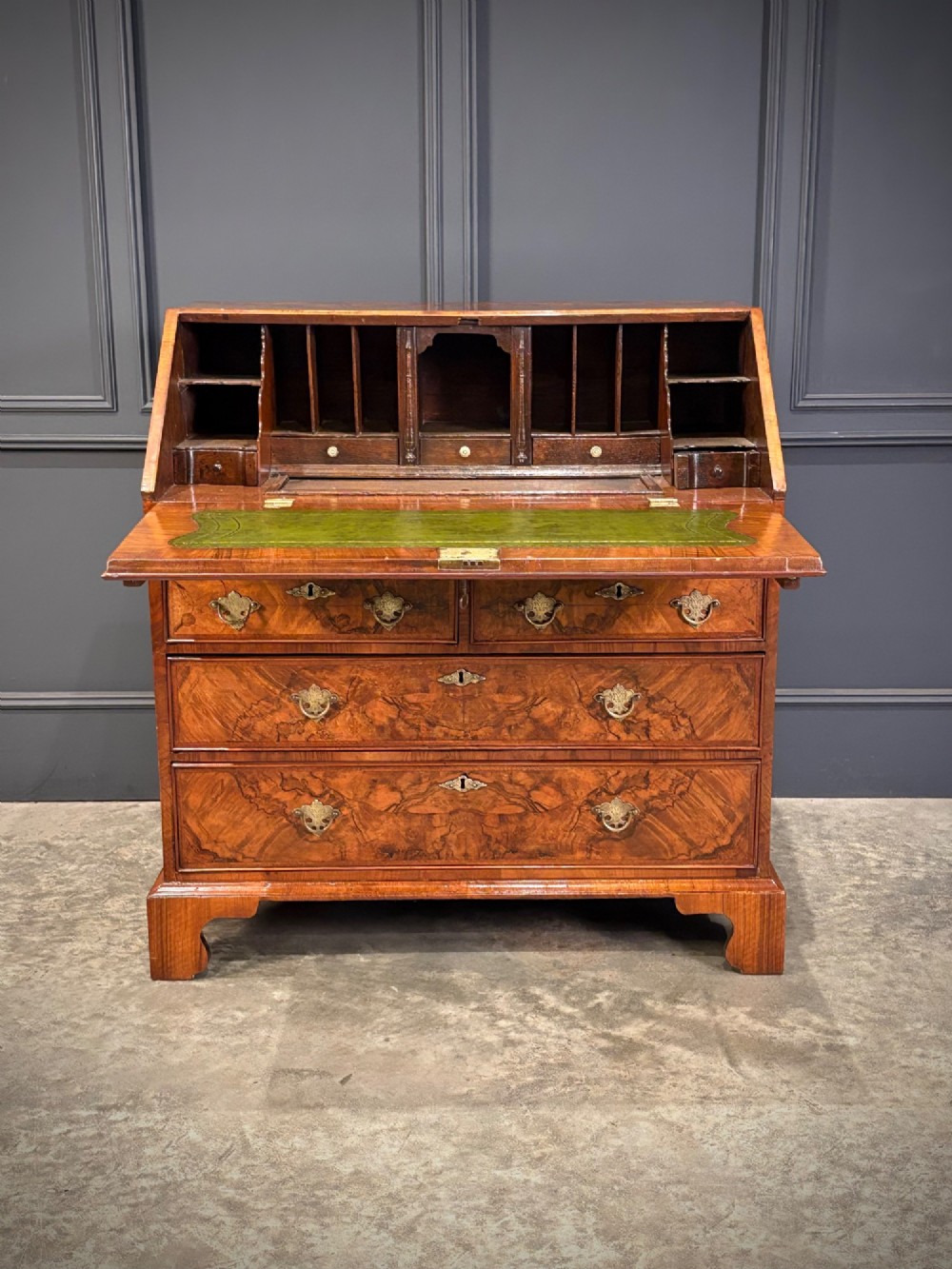 A Queen Anne style writing bureau crafted from figured walnut with a slant front writing flap above two short and two long drawers. View V