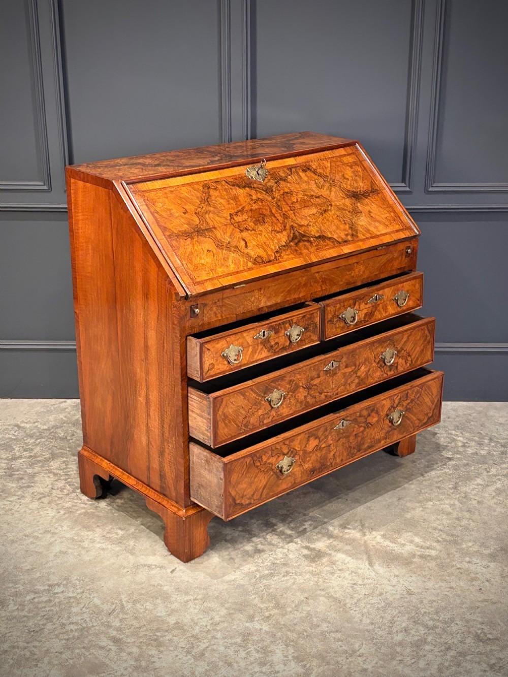A Queen Anne style writing bureau crafted from figured walnut with a slant front writing flap above two short and two long drawers. View VII