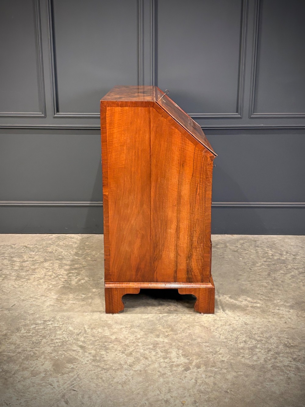 A Queen Anne style writing bureau crafted from figured walnut with a slant front writing flap above two short and two long drawers. View X