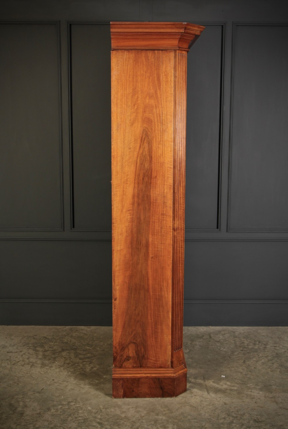 A tall Victorian burr walnut bookcase featuring open upper shelving over a double-door lower cupboard with fluted side pilasters. View XV