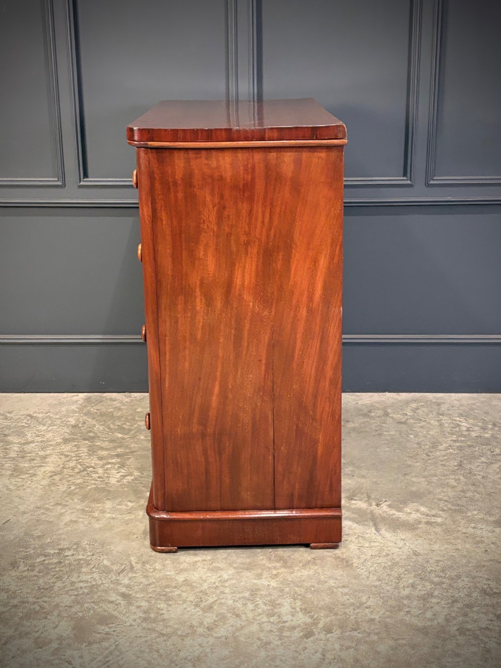 A Victorian mahogany chest of drawers with two short drawers over three long drawers, featuring turned wooden handles and a solid plinth base. View VIII