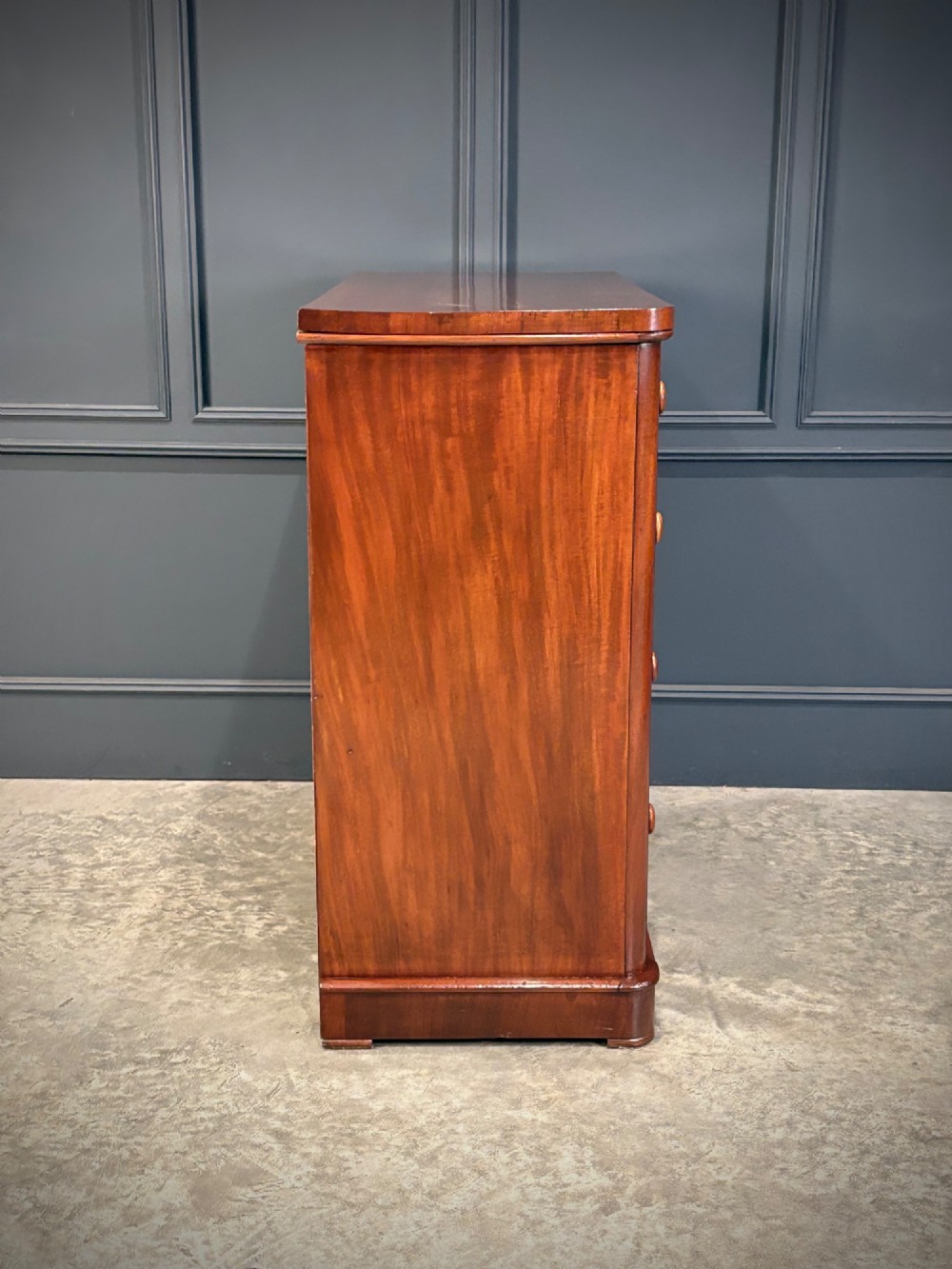A Victorian mahogany chest of drawers with two short drawers over three long drawers, featuring turned wooden handles and a solid plinth base. View X