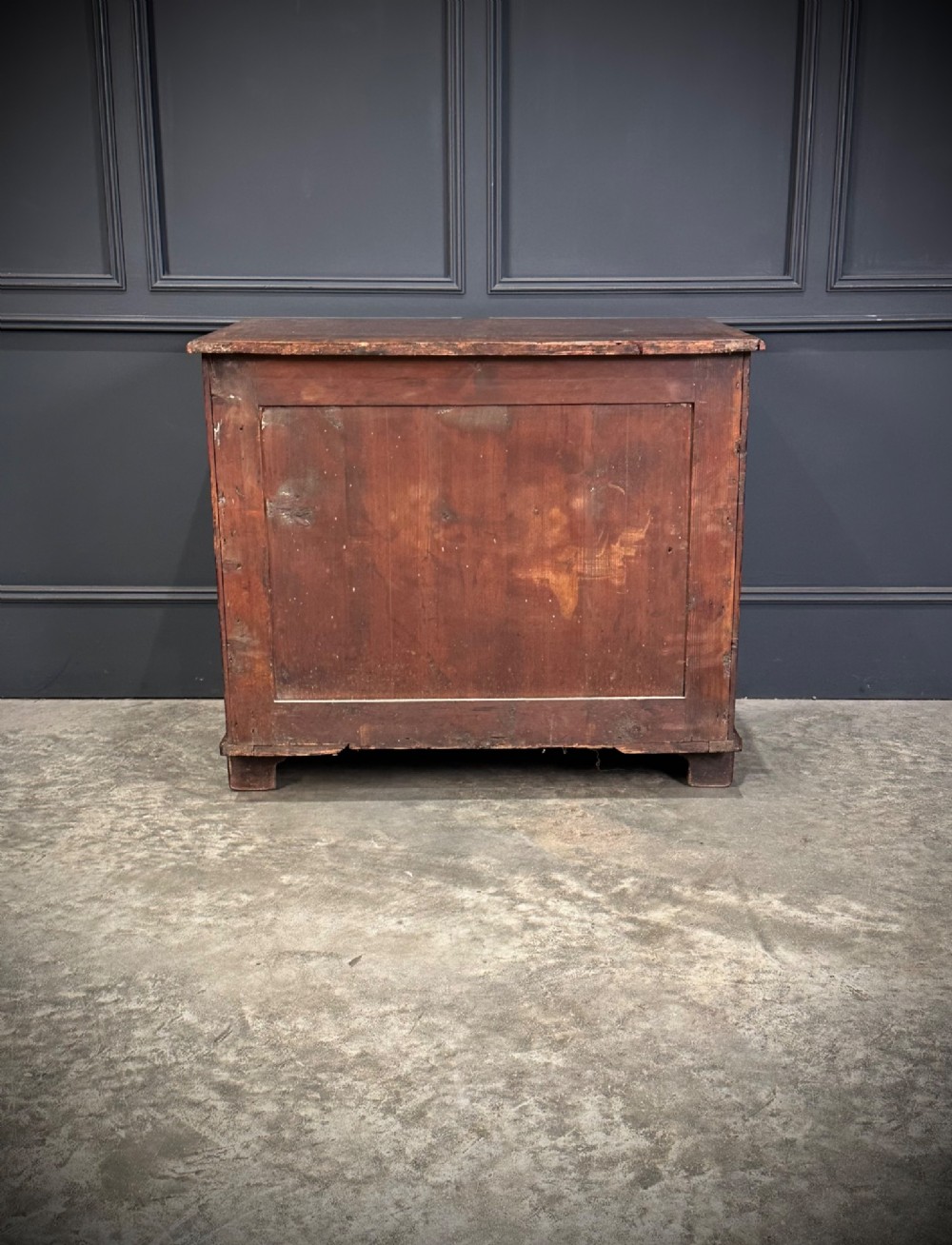An 18th-century walnut kneehole desk featuring a flat top, multiple small drawers with brass drop handles, a recessed central cupboard, and bracket feet. View XIII