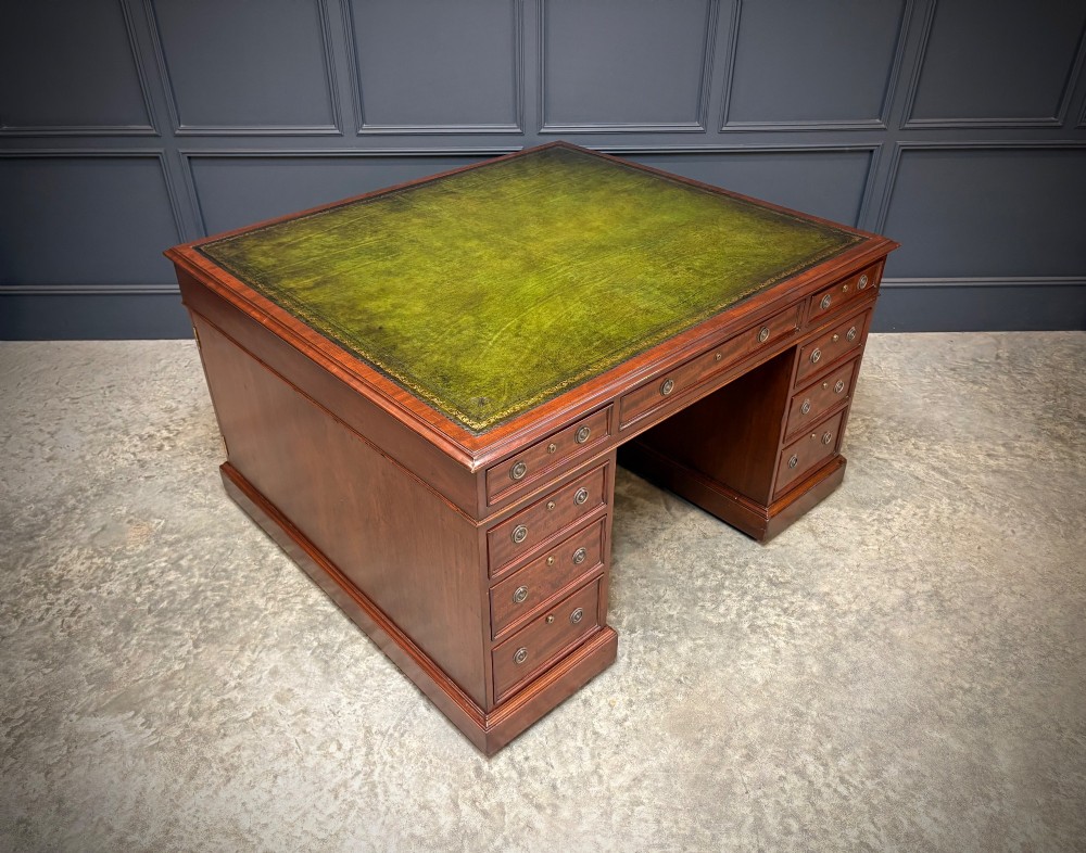 A large Victorian mahogany partners desk with a green leather inset top surface and twin pedestals fitted with wooden drawer pulls. View II