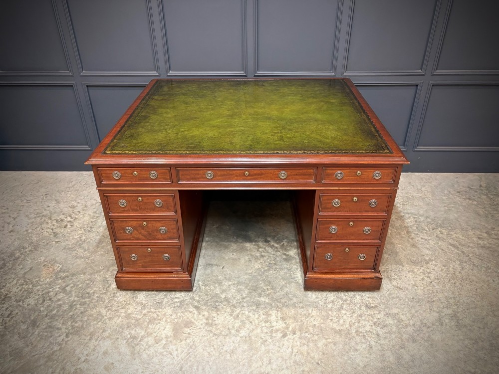A large Victorian mahogany partners desk with a green leather inset top surface and twin pedestals fitted with wooden drawer pulls. View V