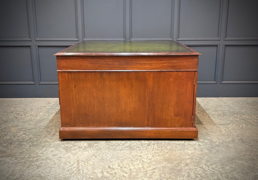 A large Victorian mahogany partners desk with a green leather inset top surface and twin pedestals fitted with wooden drawer pulls. View VI