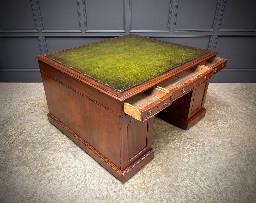 A large Victorian mahogany partners desk with a green leather inset top surface and twin pedestals fitted with wooden drawer pulls. View VII