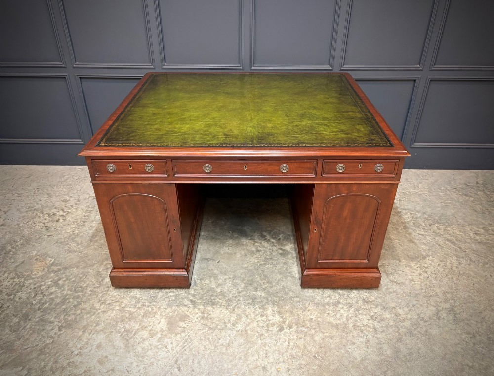 A large Victorian mahogany partners desk with a green leather inset top surface and twin pedestals fitted with wooden drawer pulls. View VIII