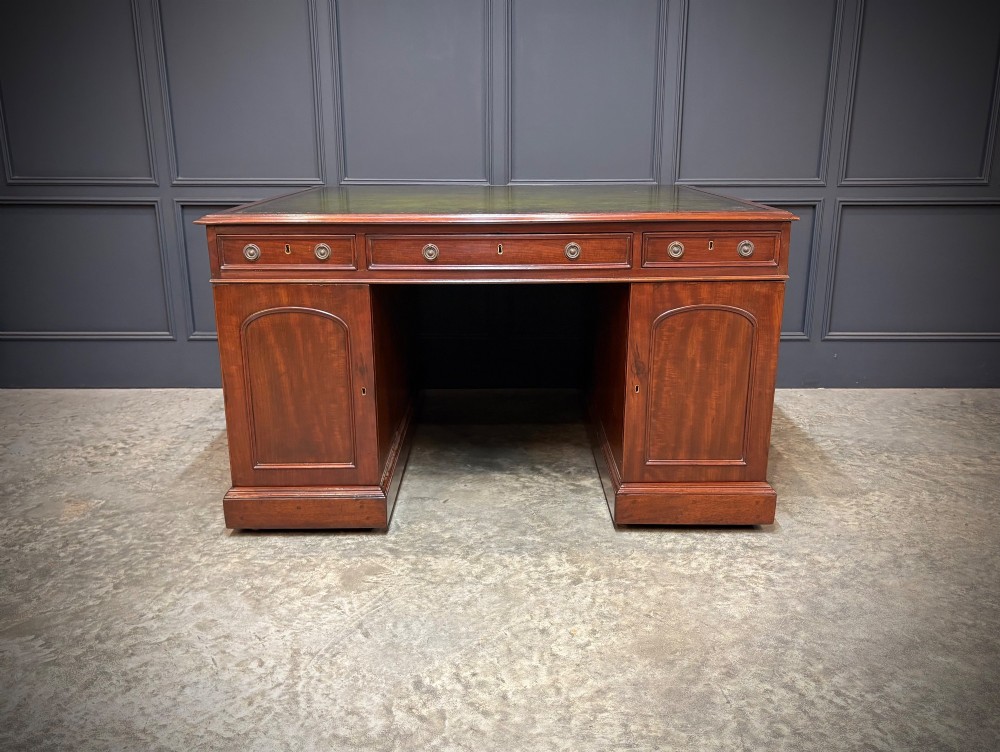 A large Victorian mahogany partners desk with a green leather inset top surface and twin pedestals fitted with wooden drawer pulls. View IX