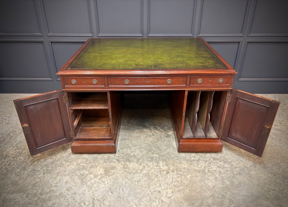 A large Victorian mahogany partners desk with a green leather inset top surface and twin pedestals fitted with wooden drawer pulls. View X