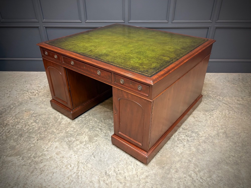 A large Victorian mahogany partners desk with a green leather inset top surface and twin pedestals fitted with wooden drawer pulls. View XI