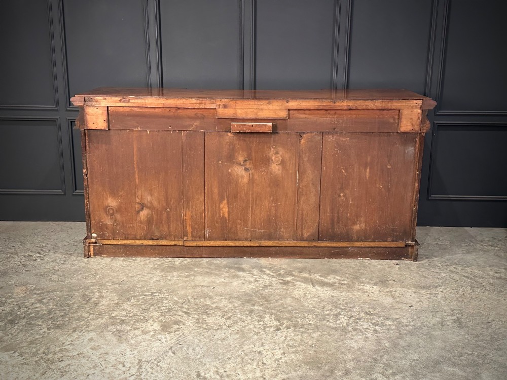 A Victorian mahogany four-door breakfront sideboard featuring arched panel doors, carved support brackets, and a long flat top surface. View XIV