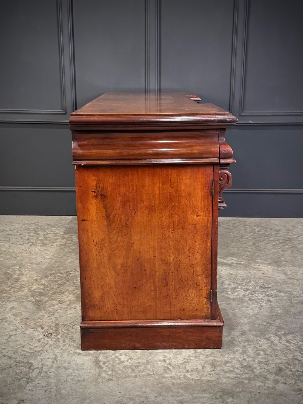 A Victorian mahogany four-door breakfront sideboard featuring arched panel doors, carved support brackets, and a long flat top surface. View XV