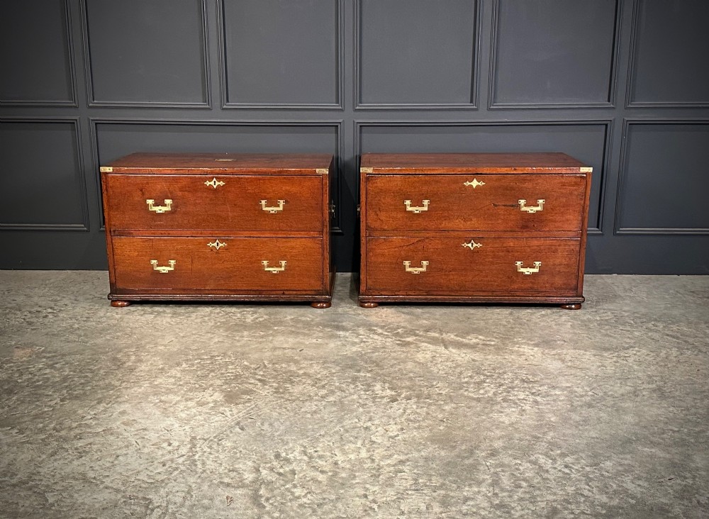 A pair of low two-drawer Regency teak military campaign chests featuring recessed brass handles, flush corner brackets, and turnip feet. View II