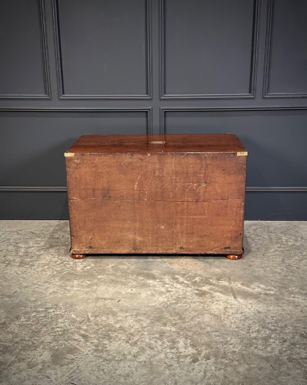 A pair of low two-drawer Regency teak military campaign chests featuring recessed brass handles, flush corner brackets, and turnip feet. View X