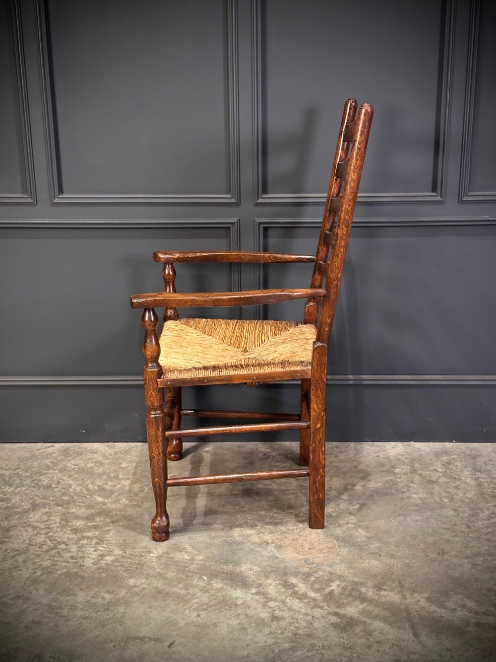 A set of eight dark oak ladder back dining chairs featuring woven rush seats, shaped back slats, and turned front legs. View XI