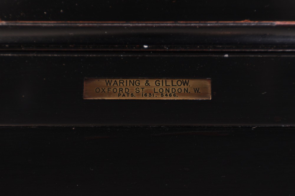 An ebonised wooden mechanical drinks table featuring opening top leaves that elevate a tray set with clear glassware, resting on tapered legs with brass castors. View VI