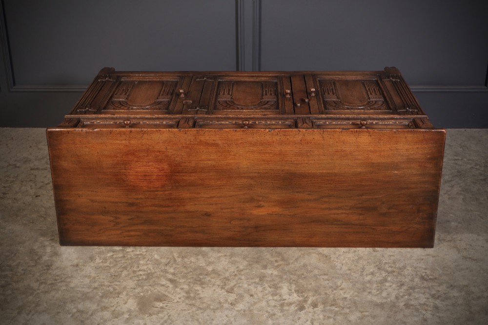 A solid oak sideboard featuring three upper drawers over four cupboard doors with carved roundhead arches and turned wooden handles. View XIII