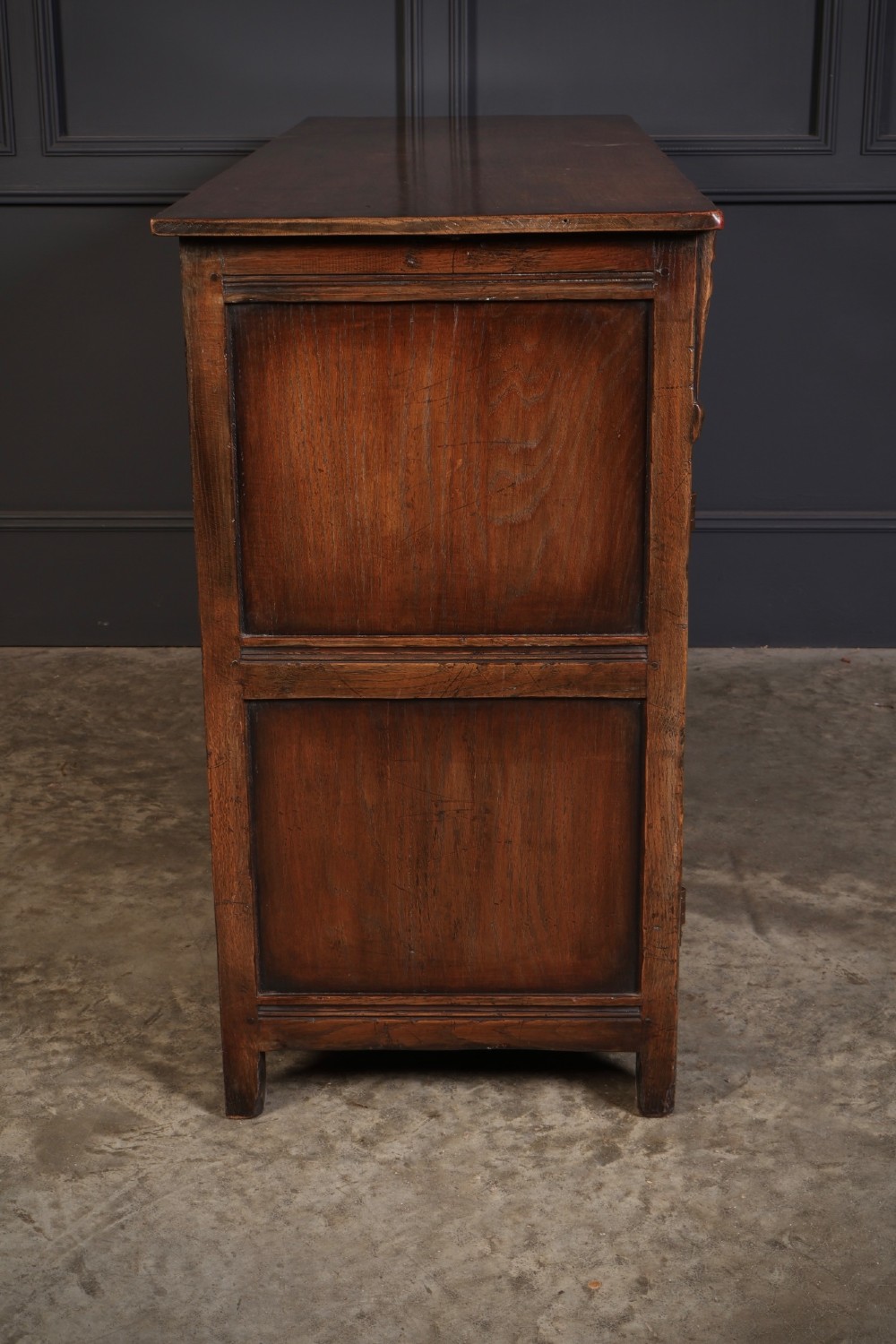A solid oak sideboard featuring three upper drawers over four cupboard doors with carved roundhead arches and turned wooden handles. View XIV