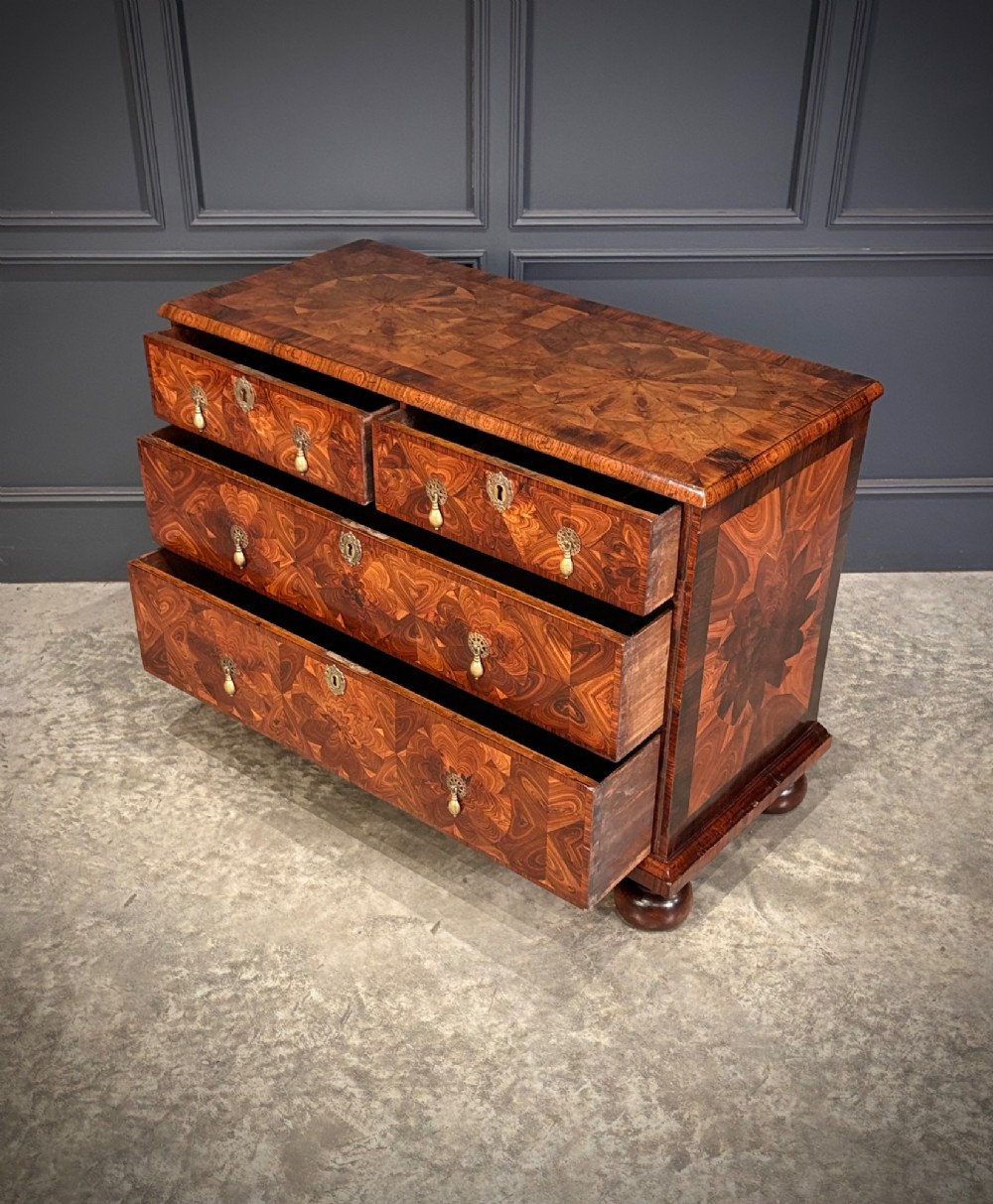 A seventeenth-century kingwood chest of drawers featuring geometric oyster veneering, brass teardrop handles, and turned bun feet. View VIII