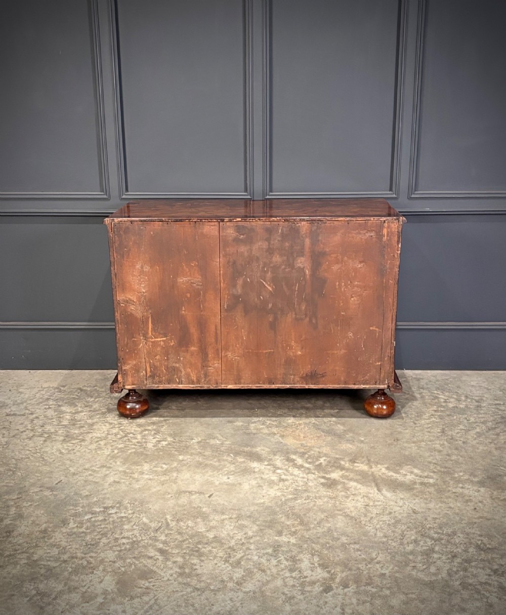 A seventeenth-century kingwood chest of drawers featuring geometric oyster veneering, brass teardrop handles, and turned bun feet. View XI