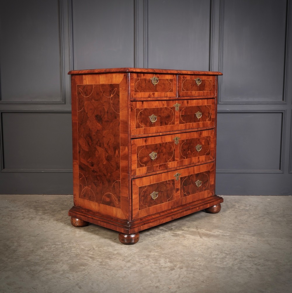 A 17th-century William and Mary chest of drawers featuring geometric oyster veneer, boxwood stringing, brass drop handles, and turned bun feet. View II