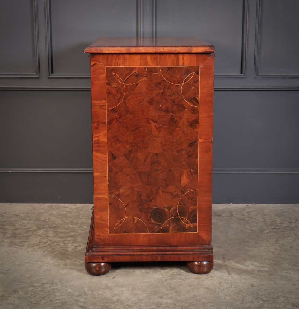 A 17th-century William and Mary chest of drawers featuring geometric oyster veneer, boxwood stringing, brass drop handles, and turned bun feet. View VI