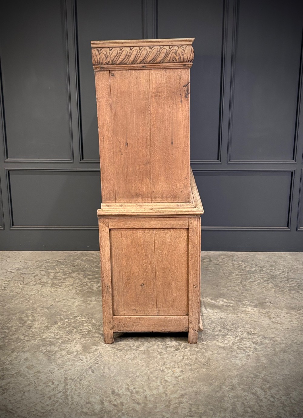 An 18th-century light oak two-piece cupboard on chest featuring detailed hand-carved foliate panels, cherub motifs, and carved drawer fronts. View XI