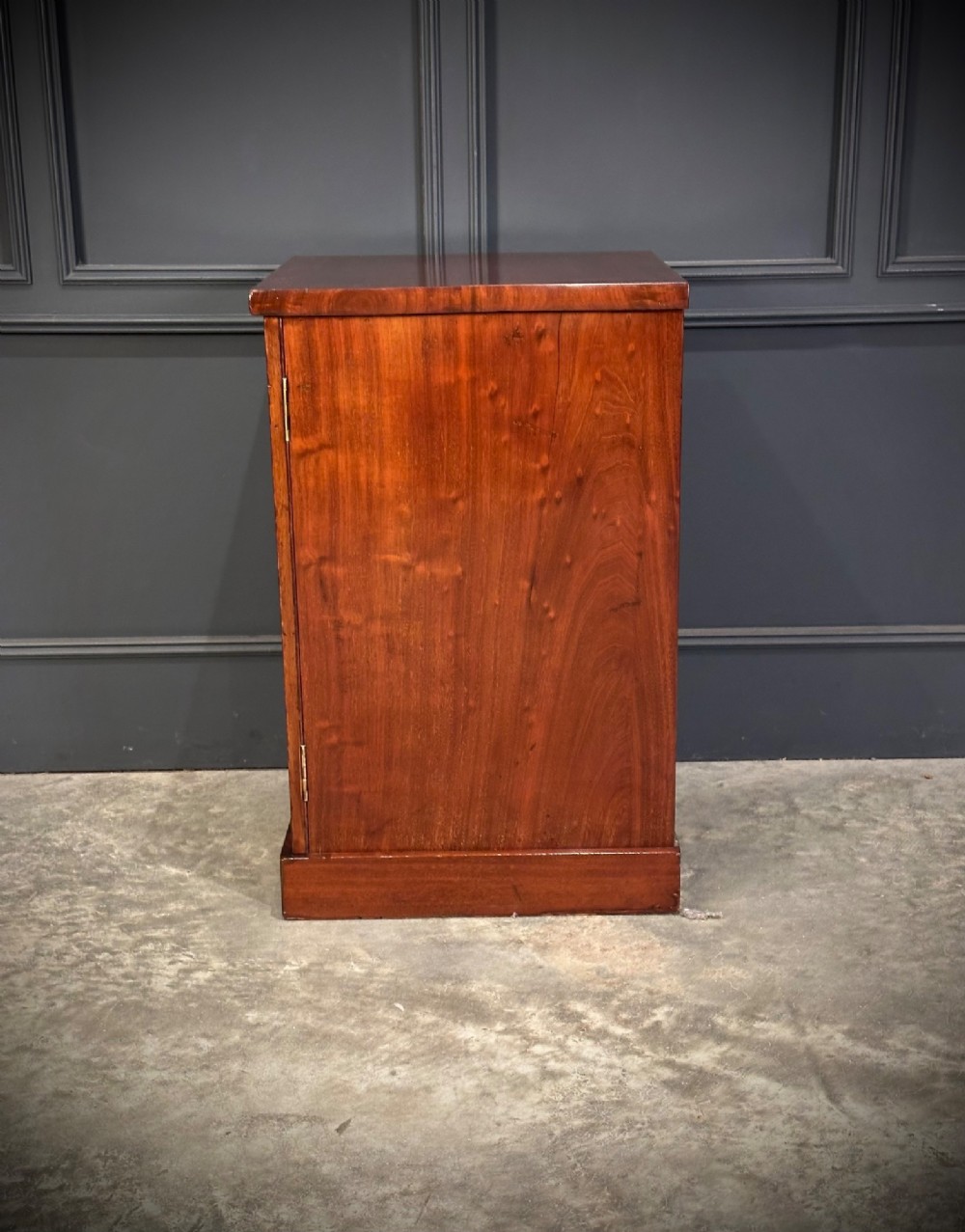 A matching pair of dark flame mahogany bedside cabinets featuring single doors with arched panels resting on solid plinth bases. View X