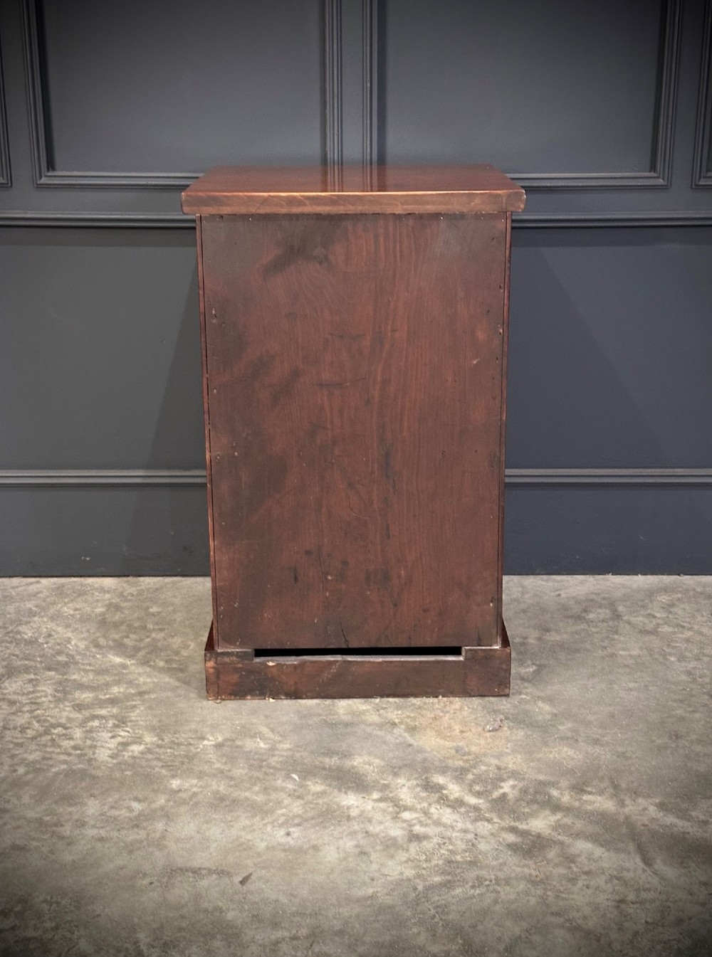 A matching pair of dark flame mahogany bedside cabinets featuring single doors with arched panels resting on solid plinth bases. View XI