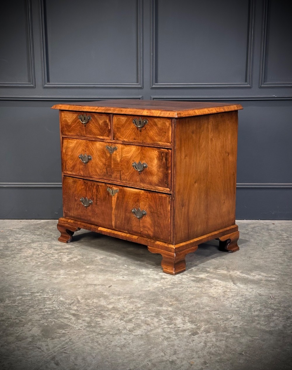 An eighteenth-century Queen Anne walnut chest of drawers featuring two short over two long graduated drawers, brass handles, and shaped bracket feet. View VIII