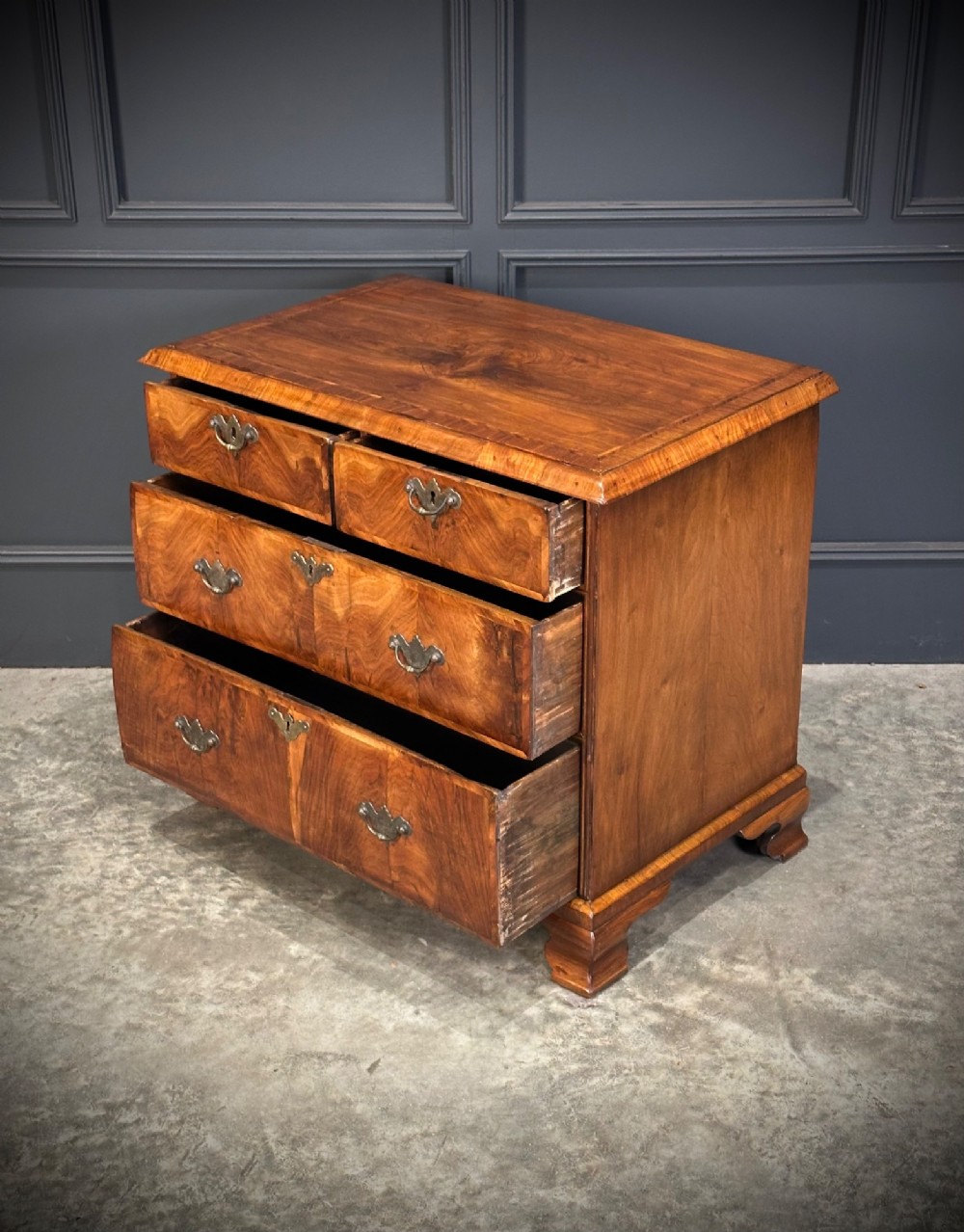 An eighteenth-century Queen Anne walnut chest of drawers featuring two short over two long graduated drawers, brass handles, and shaped bracket feet. View IX