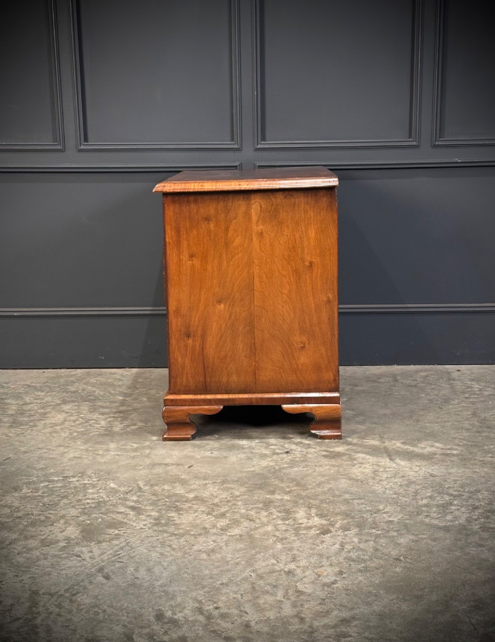 An eighteenth-century Queen Anne walnut chest of drawers featuring two short over two long graduated drawers, brass handles, and shaped bracket feet. View X