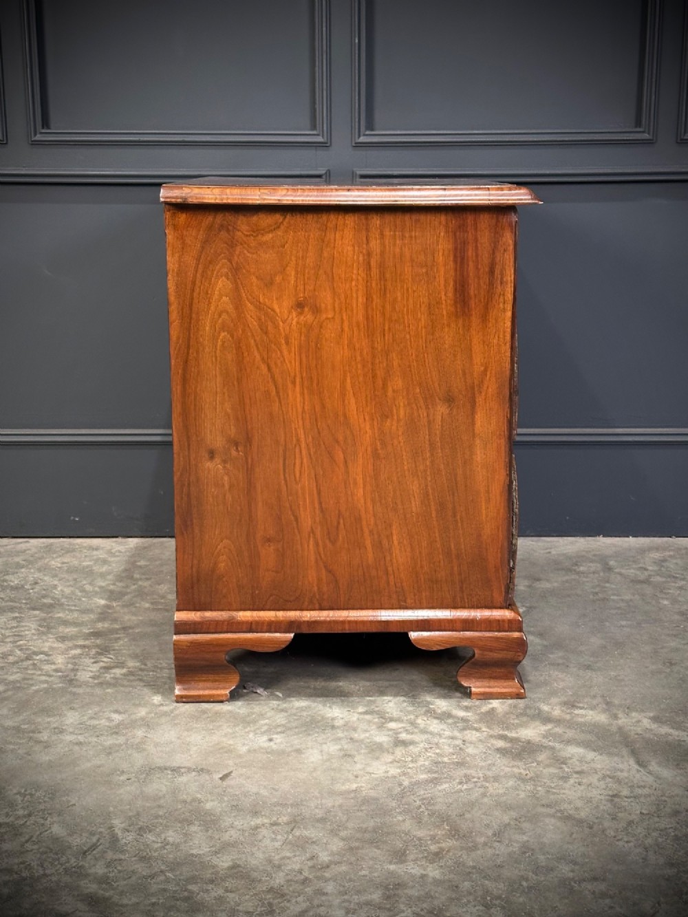 An eighteenth-century Queen Anne walnut chest of drawers featuring two short over two long graduated drawers, brass handles, and shaped bracket feet. View XII
