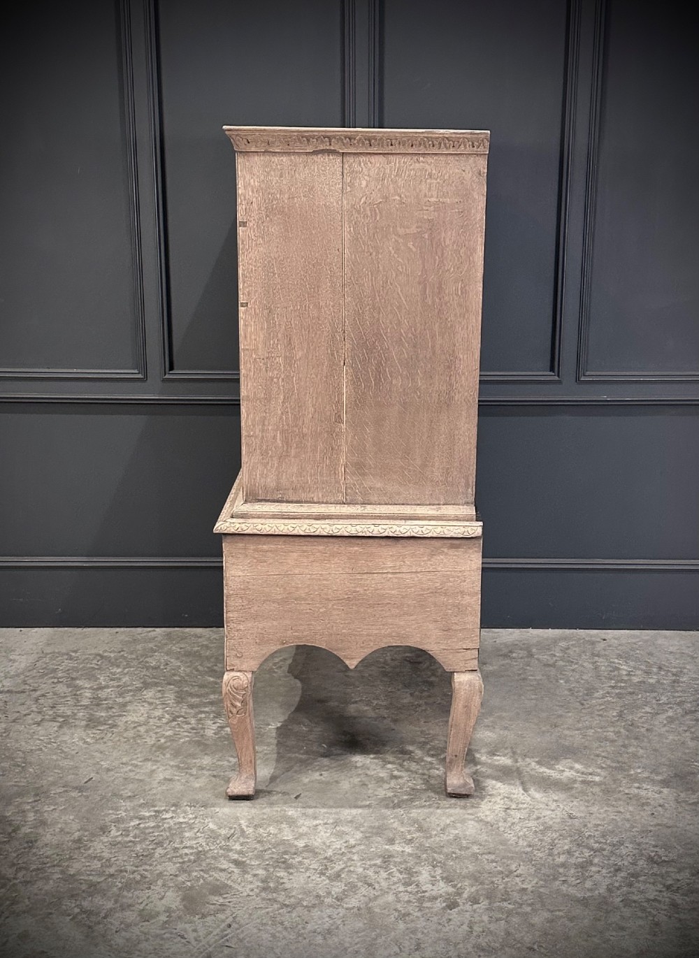 An 18th-century bleached oak chest on stand featuring carved foliage motifs across the drawer fronts and elevated on cabriole legs. View VIII