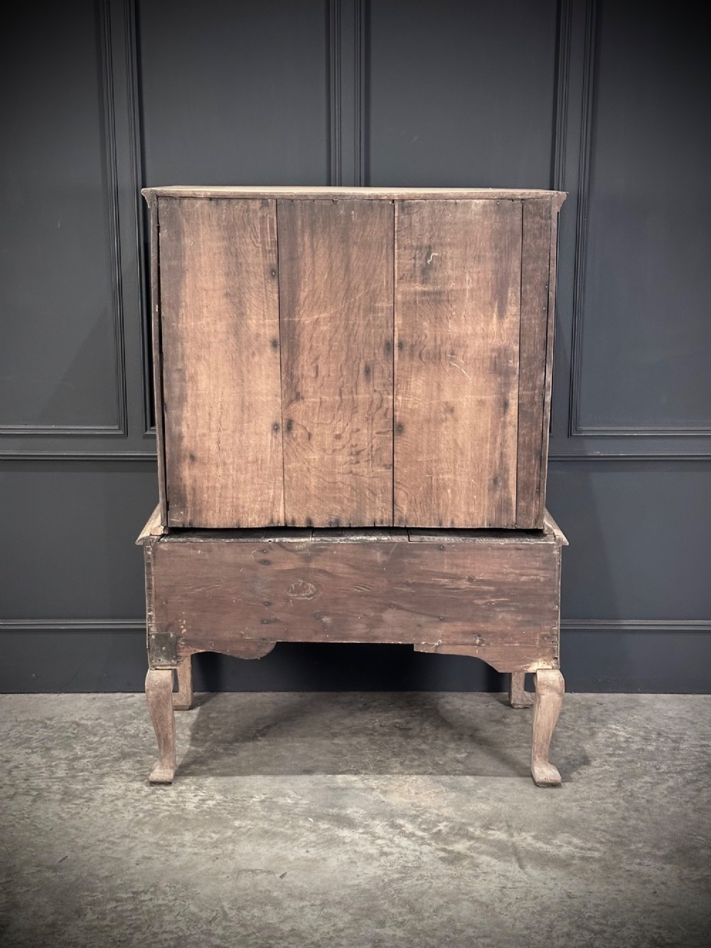An 18th-century bleached oak chest on stand featuring carved foliage motifs across the drawer fronts and elevated on cabriole legs. View IX